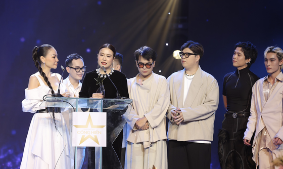 Hoang Thuy Linh (3rd, L), Khac Hung (2nd, L) and the DTAP at the awarding ceremony of Devotion Music Awards 2023 (Photo: SGGP)