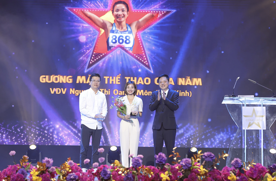 Runner Nguyen Thi Oanh (C) receives the “Face in sports of the year” award. (Photo: SGGP)