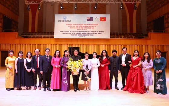 Spouses of heads of the two countries offer flowers to the academy staff. (Photo: SGGP)