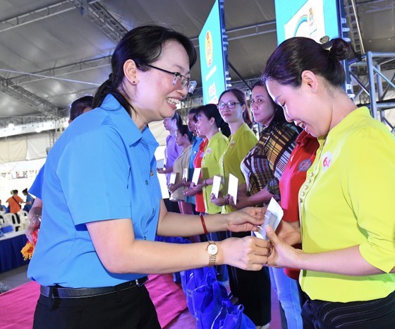 Chairwoman of the HCMC Labor Confederation Tran Thi Dieu Thuy presents gifts to disadvantaged workers at the ceremony. (Photo: SGGP)