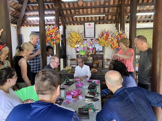 Foreign tourists visit Thanh Tien paper flower-making village in Hue City. (Photo: SGGP)