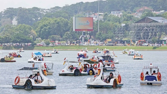 Visitors ride duck pedal boats in Xuan Huong Lake. (Photo: SGGP)