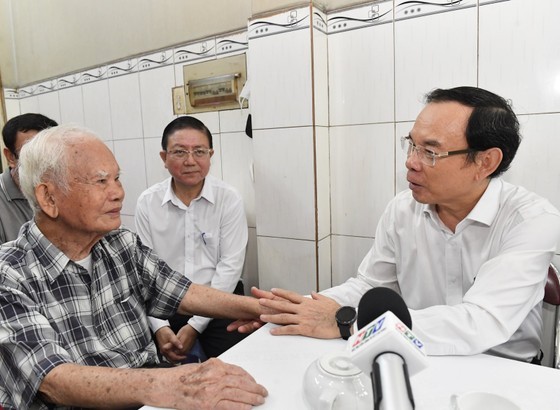 Secretary of the Municipal Party Committee Nguyen Van Nen (R) visits Mr. Ngo Quang Chinh. (Photo: SGGP)