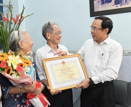 Secretary of the municipal Party Committee Nguyen Van Nen (R) extends the best health wishes and 90th birthday greetings to Mr. Nguyen Huu Trym. (Photo: SGGP)