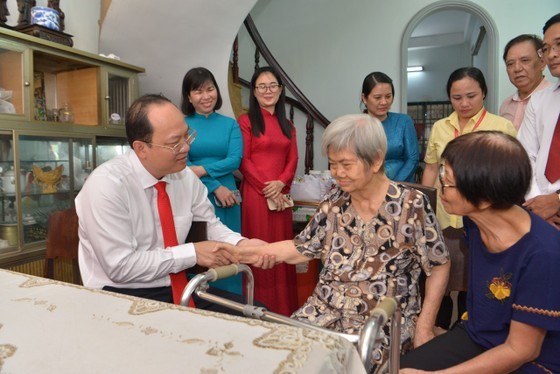 Vice Secretary of the HCMC Party Committee Nguyen Ho Hai (L) extends health wishes to Mrs. Nguyen Cam Hong. (Photo: SGGP)