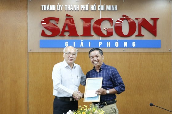 Head of the Propaganda and Education Board of the HCMC Party Committee Phan Nguyen Nhu Khue (L) presents a compliment letter to journalist Pham Hoai Nam of the SGGP Newspaper for his articles on fighting against wrong and hostile views. (Photo: SGGP)