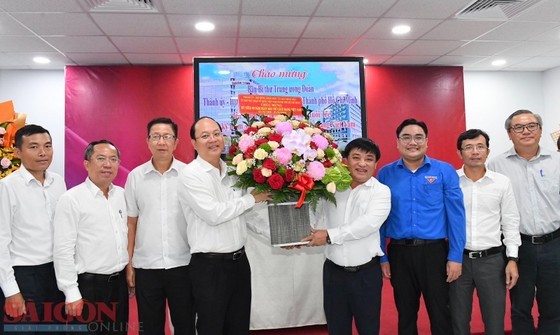 Vice Secretary of the HCMC Party Committee Nguyen Ho Hai (4th, L) offers flowers to the Tuoi Tre Newspaper's staff. (Photo: SGGP)