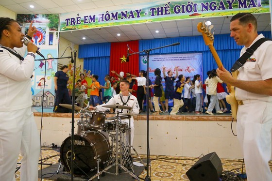 The moment US Navy sailors and children dance on the stage together (Photo: SGGP)