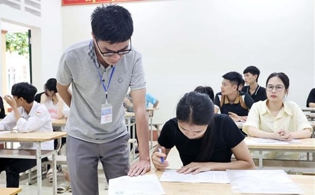 An exam supervisor helps a student verify and cross-check her information. (Photo: VNA)
