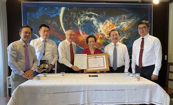 Head of the Propaganda and Education Board of the City Party Committee Phan Nguyen Nhu Khue presents a certificate of merit from the HCMC People’s Committee to Mr. Le Tat Luyen and Ms. Thuy Khue. (Photo: SGGP)