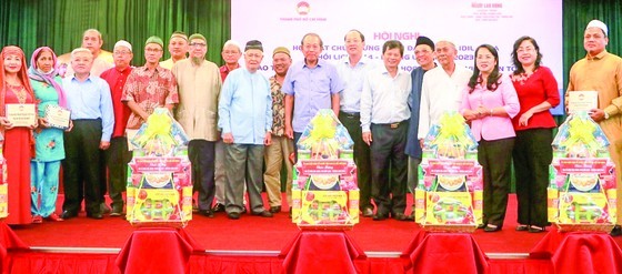 Former deputy Prime Minister Truong Hoa Binh (C) and HCMC's leaders offer presents to the representative board of the Muslim community in the city, management boards of mosques, and oratories. (Photo: SGGP)