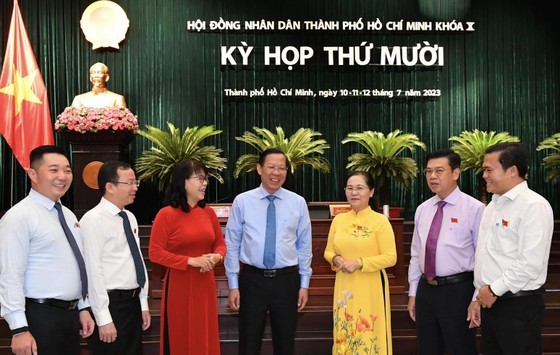 Chairpersons of the HCMC People's Council and People's Committee talk with delegates at the meeting. (Photo: SGGP)