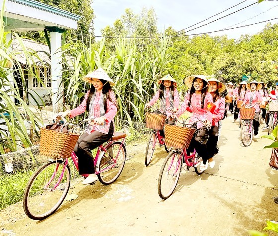 Cambodian and Laotian students take a ride on bicycles in the island commune of Thanh An in Can Gio District. (Photo: SGGP)