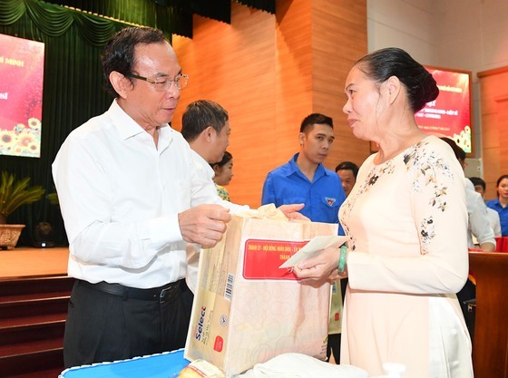 Secretary of the Party Committee Nguyen Van Nen presents gifts to relatives of war invalids. (Photo: SGGP)