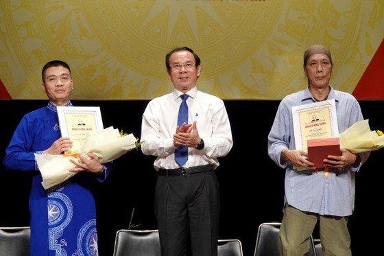 Secretary of the HCMC Party Committee Nguyen Van Nen hands over Tran Van Khe Awards to Meritorious Artist, Dr. Co Huy Hung, head of the Department of Folk Music of the Vietnam National Academy of Music, and researcher, and musician Bui Trong Hien. (Photo: SGGP)
