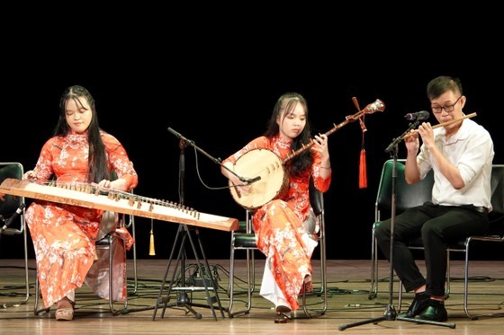 Three students of the HCMC Conservatory of Music who receive Tran Van Khe Scholarships perform a folk song, Ly Dem Trang (Song of a moon night). (Photo: SGGP)