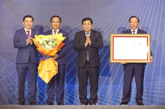 Minister of Planning and Investment Nguyen Chi Dung (2nd, R) hands over the PM's decision on approving Long An Development Master Plan for 2021-2030 with a vision to 2050 to the province's leaders. (Photo: SGGP)