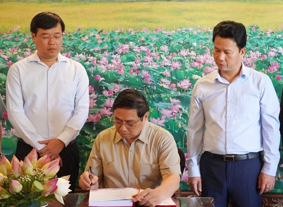 Prime Minister gives a writing in tribute to patriotic Confucian scholar Nguyen Sinh Sac. (Photo: SGGP)