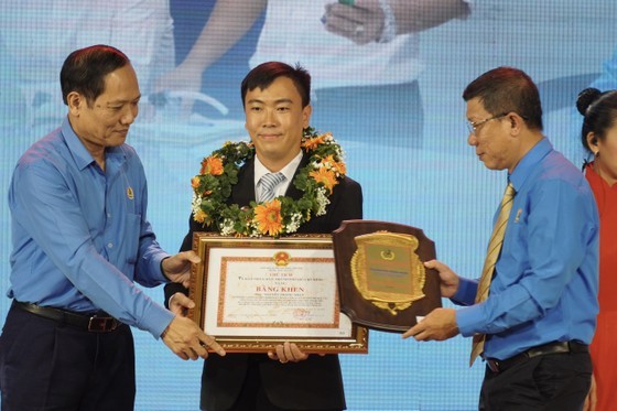 Head of the technical operation department of Phu Hoa Tan Water Supply Joint Stock Company under Saigon Water Corporation (SAWACO), Nguyen Trong Nhan (C) receives Ton Duc Thang Award. (Photo: SGGP)