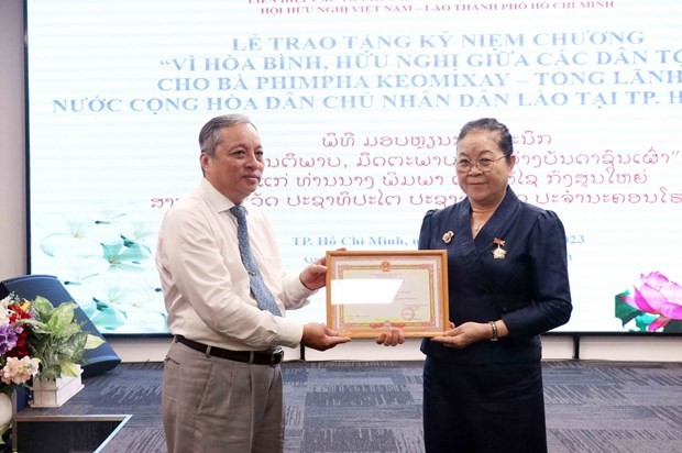 Lao Consul General in HCMC Phimpha Keomixay (R) is awarded an insignia “For peace and friendship among nations” by the Vietnam Union of Friendship Organisations (VUFO) on August 22. (Photo: VNA)