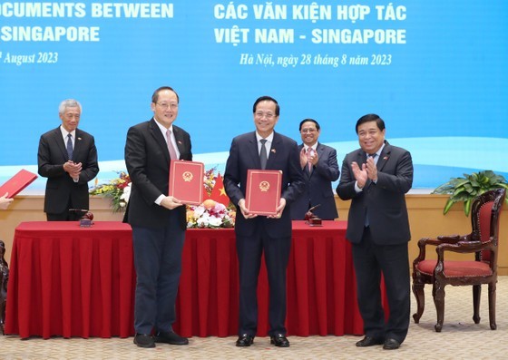 Vietnamese Minister of Planning and Investment Nguyen Chi Dung (R), Minister of Labor, Invalids and Social Affairs Dao Ngoc Dung (C), and Singaporean Minister of Industry and Trade Tan See Leng sign a Memorandum of Understanding (MoU) on the Vietnam-Singapore Innovation Talent Exchange Program. (Photo: SGGP)