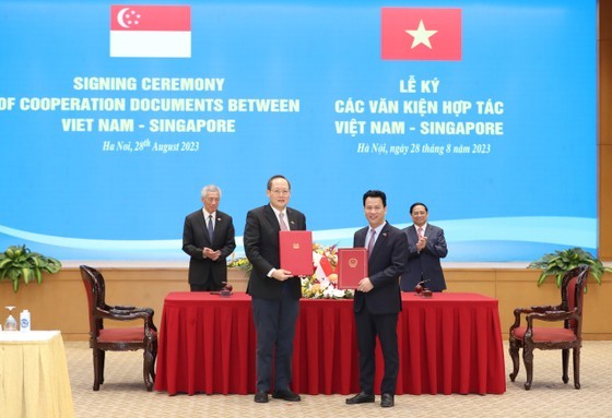 Vietnamese Minister of National Resources and Environment Dang Quoc Khanh (R) and Singaporean Minister of Manpower Tan See Leng sign a letter of intent between the two sides. (Photo: SGGP)