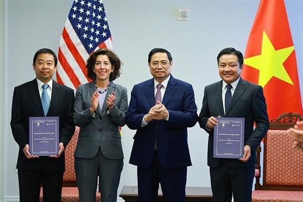 Prime Minister Pham Minh Chinh (second from right) and Secretary of Commerce Gina Raimondo (second from left) at the ceremony to present investment and business registration certificates to Son My LNG port warehouse company limited on May 11, 2022 (Photo: VNA)