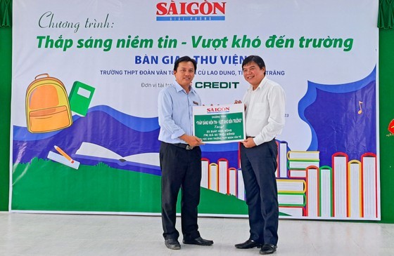 Editor-in-chief of the SGGP Newspaper Tang Huu Phong (R) offers 20 scholarships to students of the Doan Van To High School. (Photo: SGGP)