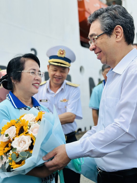 Head of the Organization Commission of the HCMC Party Committee Nguyen Phuoc Loc offers flowers to delegates. (Photo: SGGP)