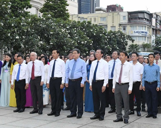 Delegates offer flowers at Ho Chi Minh Statue Park in front of the City Hall in Nguyen Hue walking street. (Photo: SGGP)