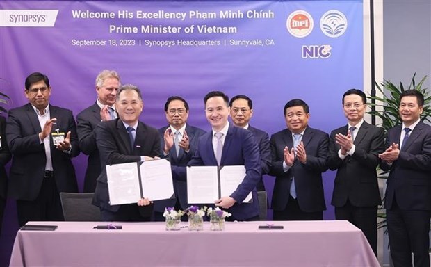 PM Pham Minh Chinh (back, third from left) and officials witness the signing of a cooperation memoranda between the Vietnamese Ministry of Information and Communications and Synopsys on September 18. (Photo: VNA)
