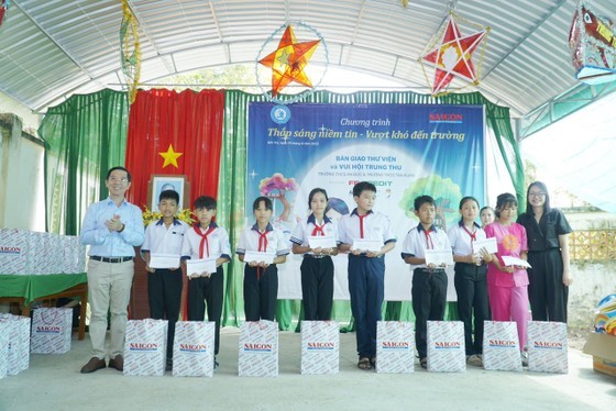 Representatives of the program offer scholarships worth VND1 million each to disadvantaged students. (Photo: SGGP)