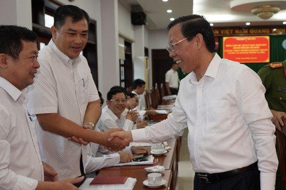 Chairman of the HCMC People’s Committee Phan Van Mai (R) meets delegates at the meeting. (Photo: SGGP)