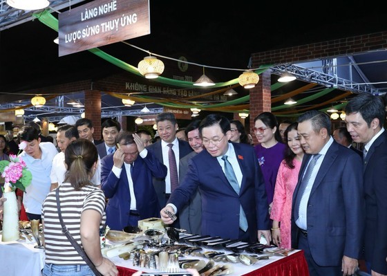 NA Chairman Vuong Dinh Hue visits a display booth at the festival. (Photo: SGGP)