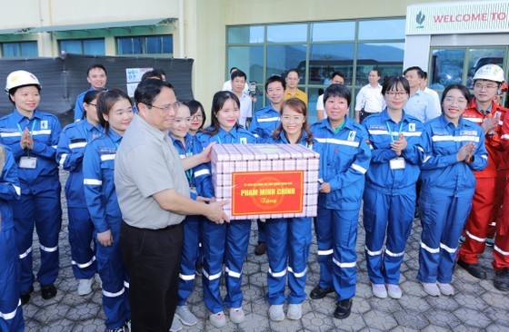 Prime Minister Pham Minh Chinh offers a gift to workers of the Nghi Son refinery and petrochemical complex. (Photo: SGGP)