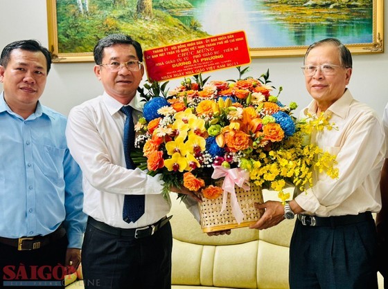 Mr. Duong Ngoc Hai wishes the teacher Duong Ai Phuong good health and expressed his appreciation for his significant contributions to the city’s development. (Photo: SGGP)