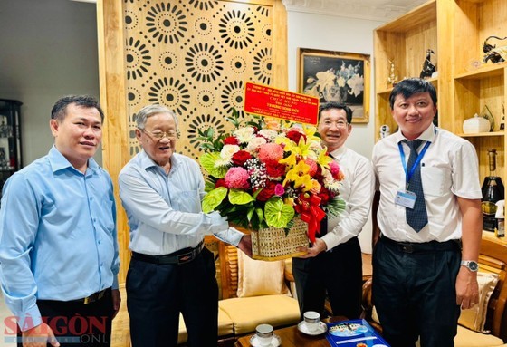 Mr. Duong Ngoc Hai offers flowers to teacher Truong Song Duc. (Photo: SGGP)