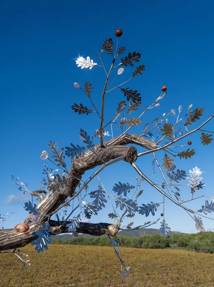 Thousands of stainless-steel leaves hanging and "flowers" that are made from colorful, reflective quartz stones on the branches create a sparkle effect as if playing with the sunlight.