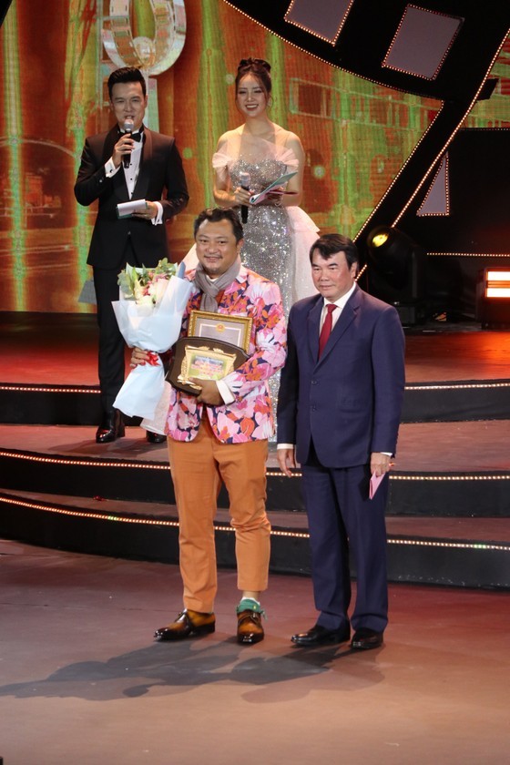Vice Chairman of the People's Committee of Lam Dong Province, head of the Steering Committee for the 23rd Vietnam Film Festival, Pham S (R) presents a special award honoring the movie filmed in the central highlands province of Lam Dong to the movie, “Em va Trinh” (Trinh and I). (Photo: SGGP)