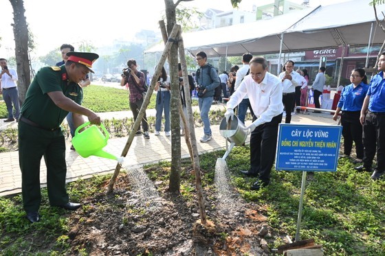 Former Secretary of the HCMC Party Committee Nguyen Thien Nhan (R) waters trees in the park. (Photo: SGGP) Former Secretary of the HCMC Party Committee Nguyen Thien Nhan (R) waters trees in the park. (Photo: SGGP)