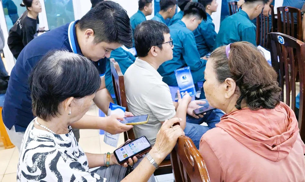 Nhân viên Công ty Cấp nước hướng dẫn và hỗ trợ người dân cài đặt ứng dụng SAWACO CSKH