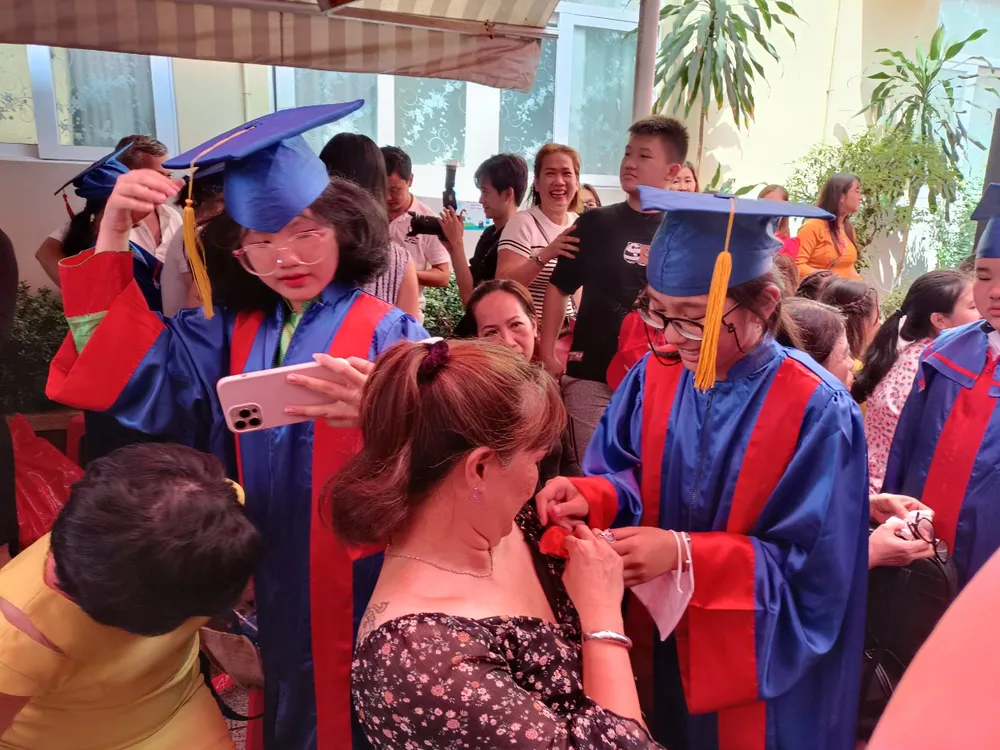 Một học sinh cài bông hồng thay lời cảm ơn mẹ