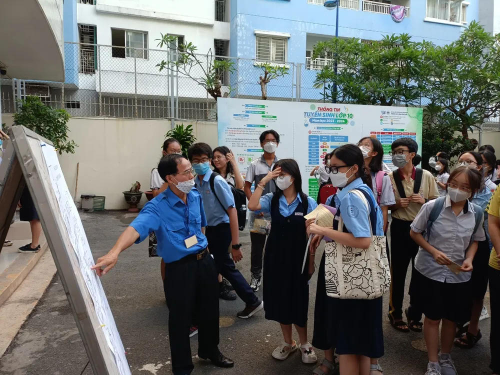 Nhân viên tại điểm thi hỗ trợ thí sinh hướng di chuyển lên đúng phòng thi theo giấy báo dự thi