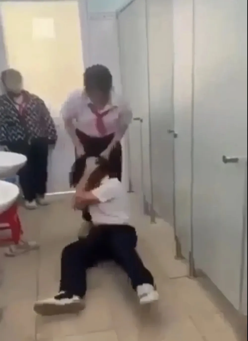Hình ảnh cắt ra từ clip học sinh đánh bạn tại nhà vệ sinh Trường THCS Nguyễn Văn Trỗi
