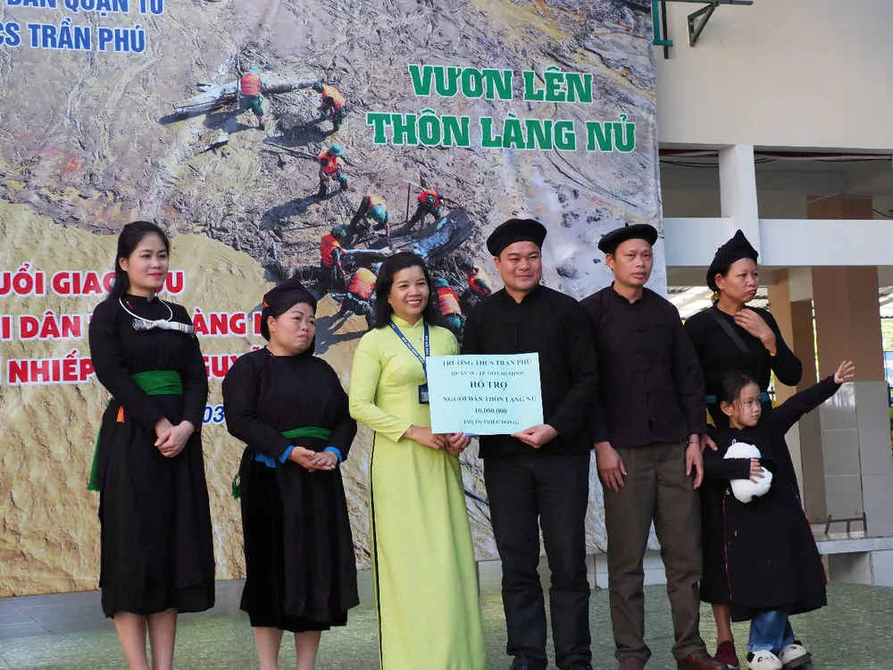 Cô Ngô Ngọc Uyên, Hiệu trưởng Trường THCS Trần Phú trao tặng phần quà 10 triệu đồng cho Trưởng thôn Làng Nủ