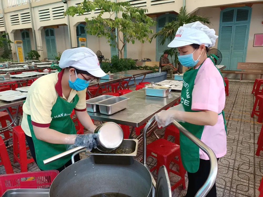 Nhân viên phục vụ bán trú phân chia suất ăn tại Trường THCS Võ Trường Toản (phường Sài Gòn). Ảnh minh họa.