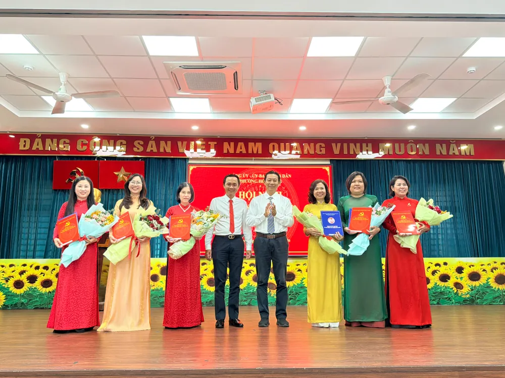 Ông Lương Vũ Ngữ, Phó Bí thư Thường trực Đảng ủy phường Hòa Hưng (thứ tư từ phải qua) trao các quyết định cán bộ sau sắp xếp trường học