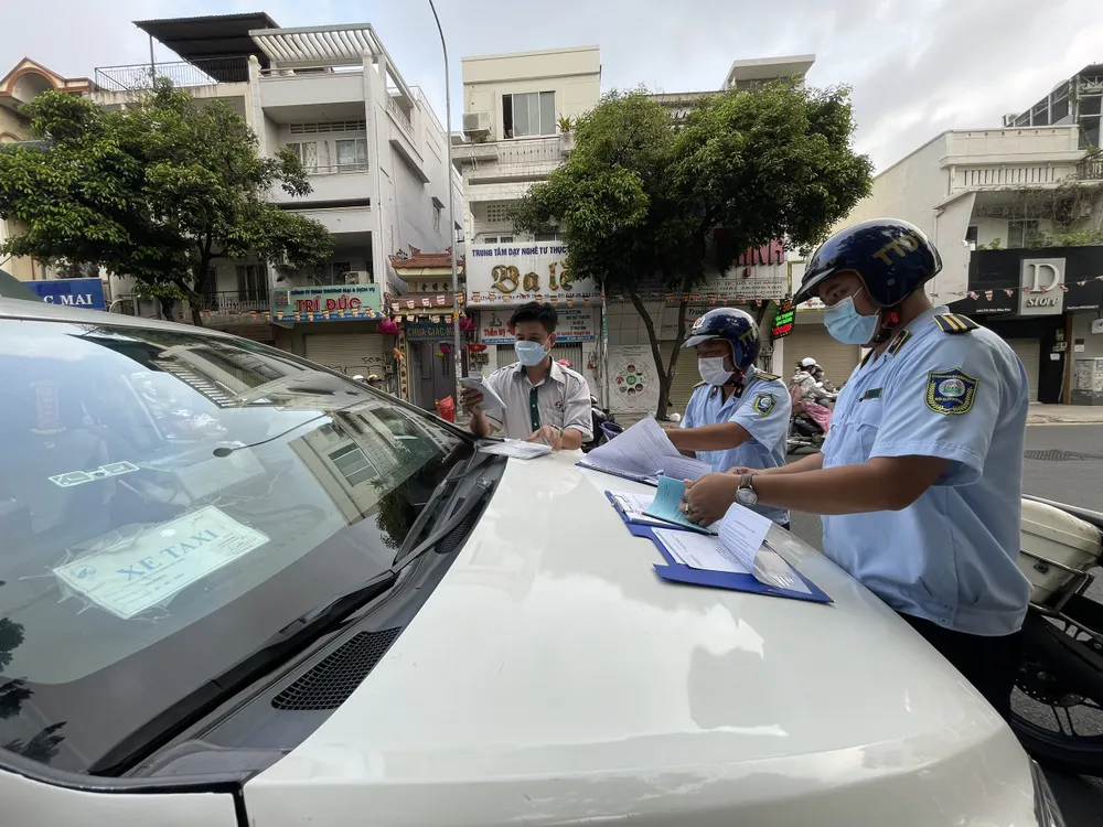 Lực lượng chức năng xử phạt phương tiện lấn chiếm vỉa hè. Ảnh: THẢO LÊ