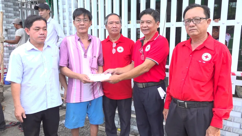 Hội Chữ thập đỏ hỗ trợ hộ dân có nhà bị rơi xuống sông. Ảnh: THANH NGHĨA