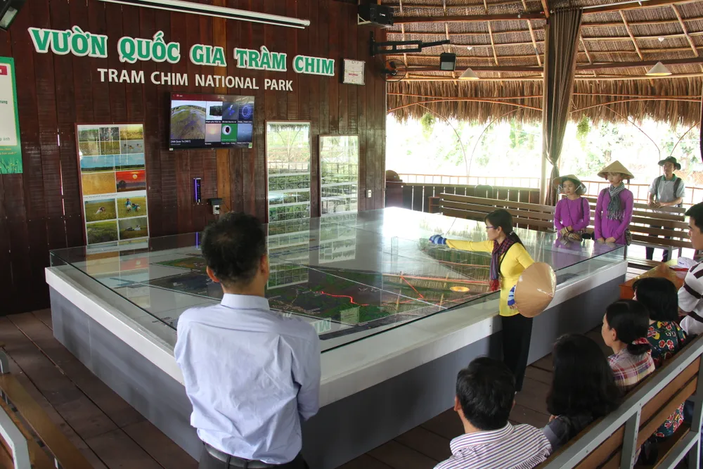 Hướng dẫn viên thuyết minh về các phân khu trong Vườn Quốc gia Tràm Chim cho du khách trước đi tham quan thực tế